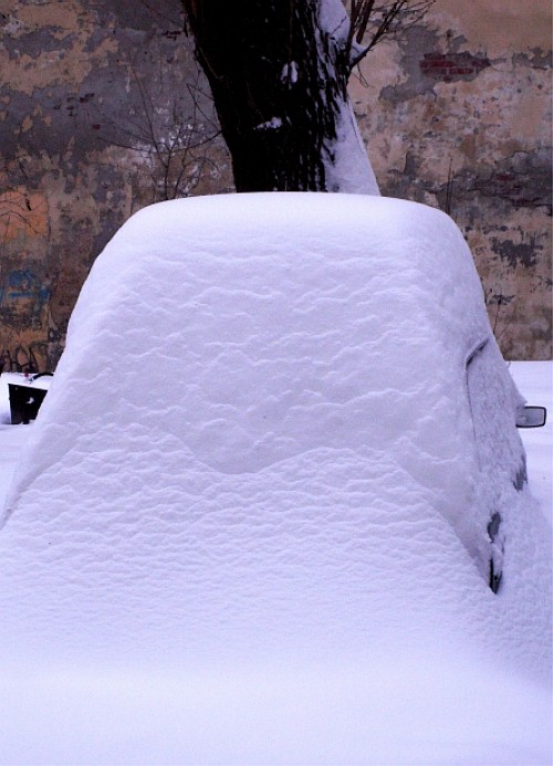 Машина под огромным слоем снега